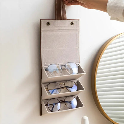 Organizador de óculos dobrável e compacto posicionado sobre mala de viagem, ideal para transporte seguro e discreto